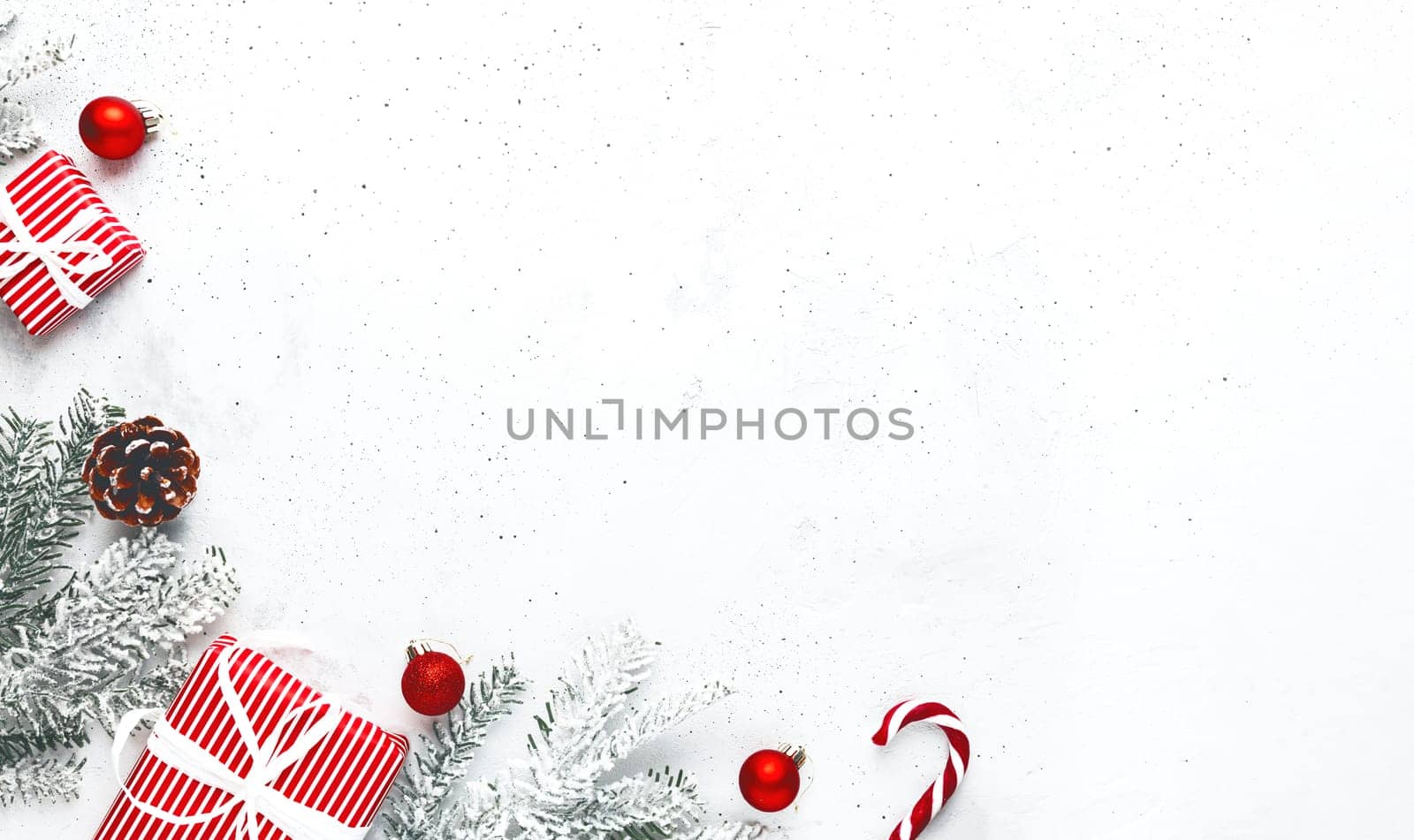 Christmas, New Year gray concrete flat lay. Red white striped present gift boxes top view. Gift ribbon and packaging paper. Christmas tree fir, cones, toy balls, wooden star. Copy space area on photo