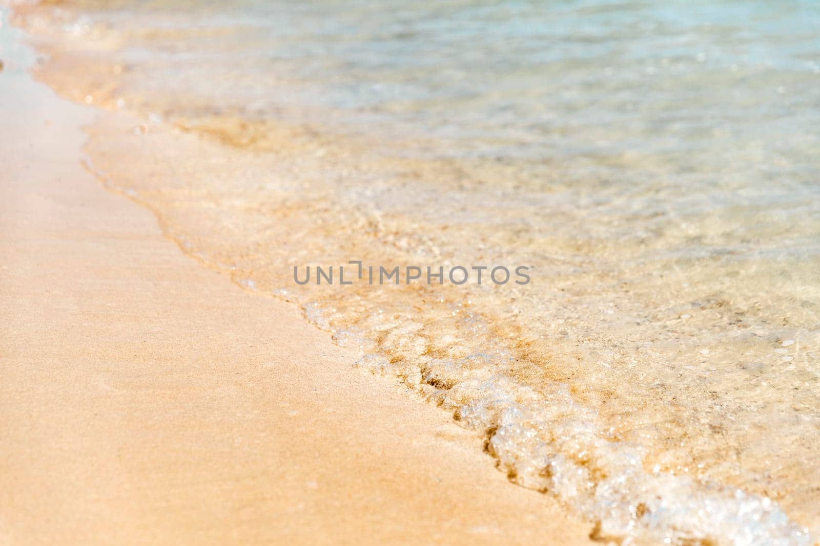Close up aerial view of crystal clear turquoise sea and soft blue ocean waves, white foam on golden sandy tropical island summer beach, holidays border frame concept background, vacation backdrop