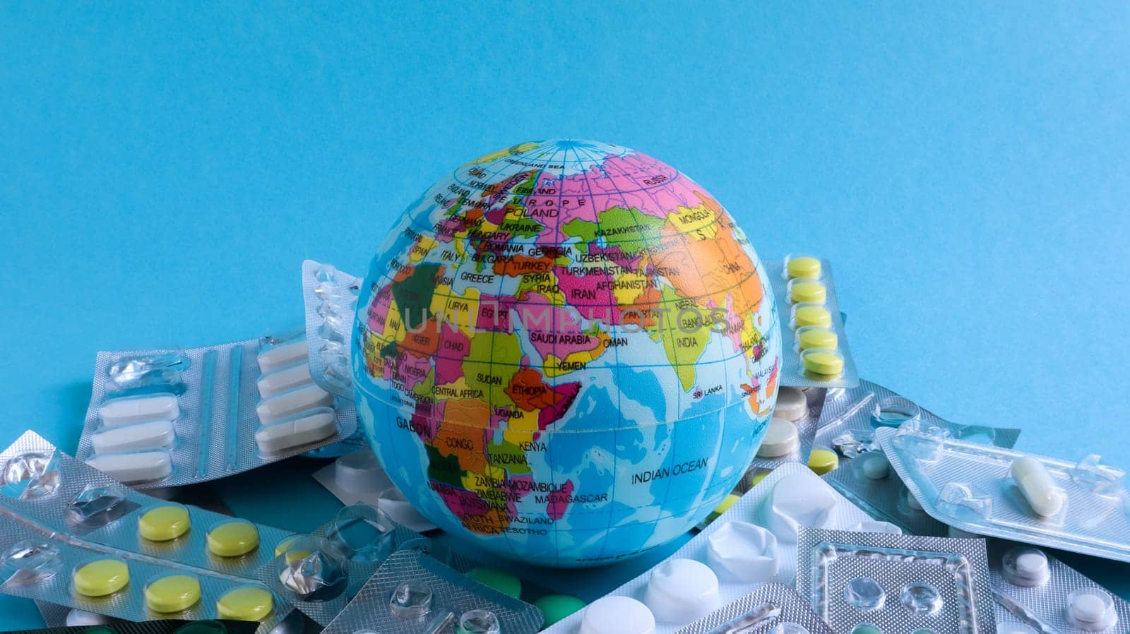 Ukraine, Kiev - April 14, 2020. The concept of a pandemic and global viral infection in America, Europe and around the world. Model of the globe and pills. A planet with packs of antiviral drugs