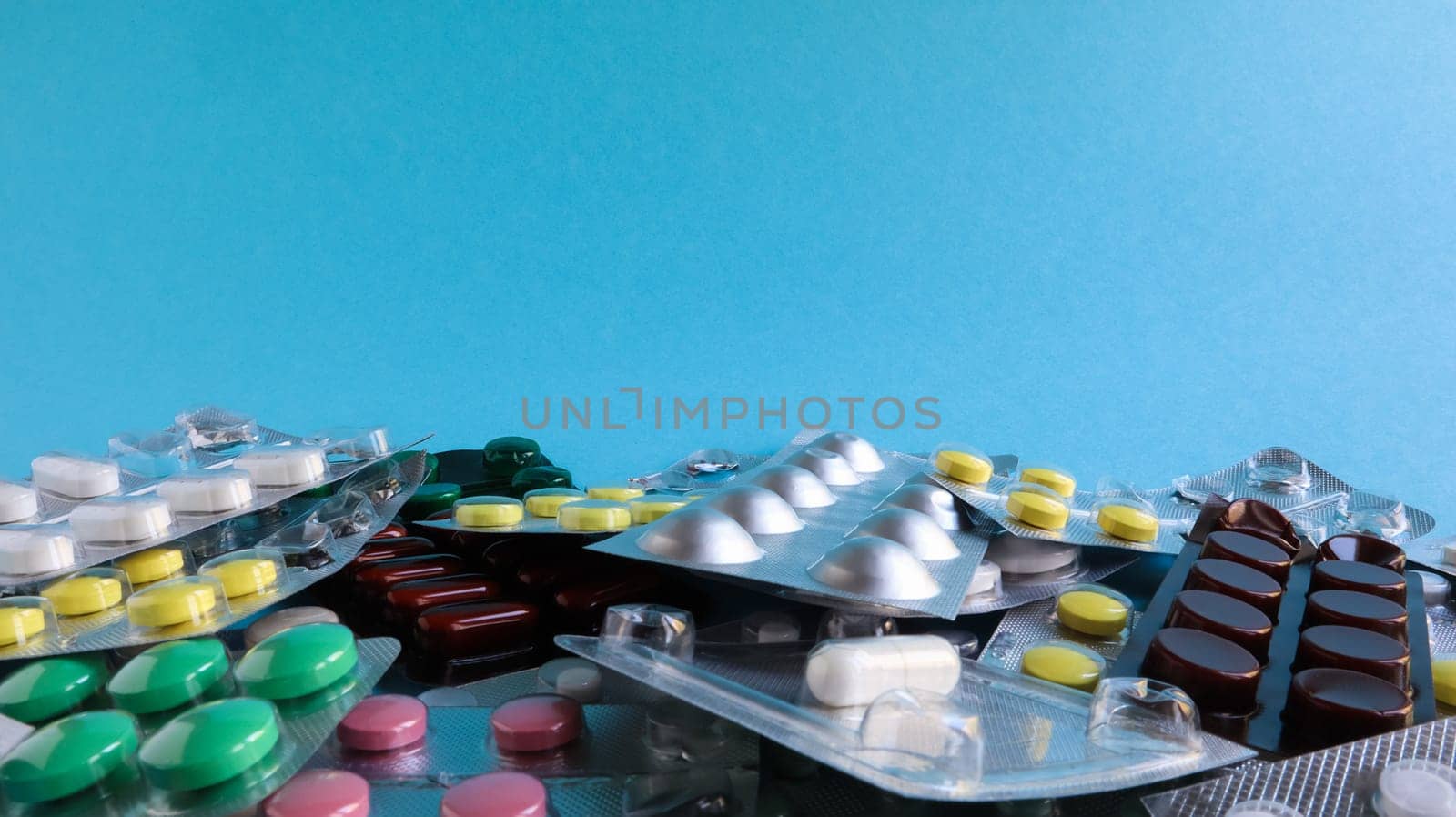Pills, capsules with medicine, vitamins in the package, in blister packs are on the table. antibiotics, multicolor antibacterial drugs. Healthcare and medicine concept. Copy space