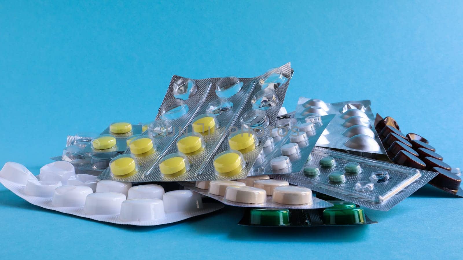 Pills, capsules with medicine, vitamins in the package, in blister packs are on the table. antibiotics, multicolor antibacterial drugs. Healthcare and medicine concept. Copy space