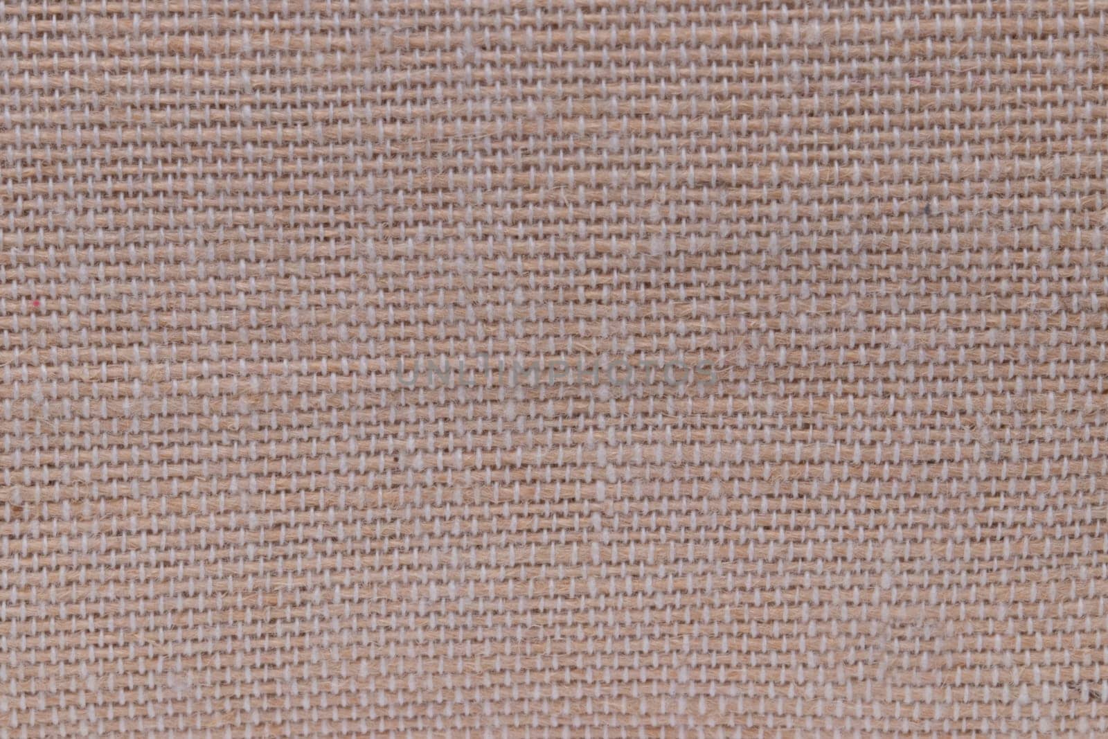 Beige fabric texture. Close-up of a brown seamless pattern for textile, bags or other garments. Macro.