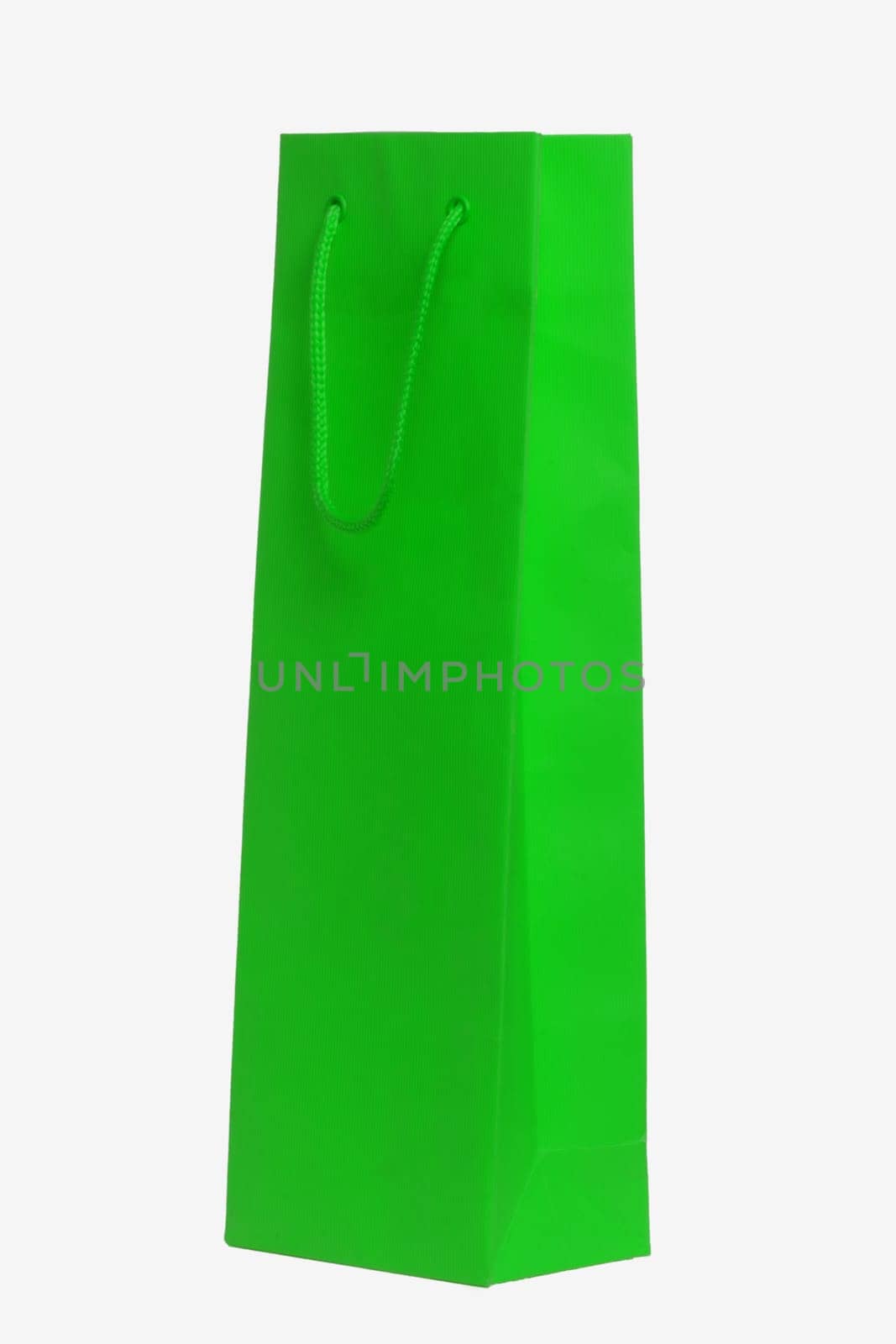 Closeup of a single green paper bag or pouch with green handle for shopping or for gifts isolated on a white background. Macro photograph.