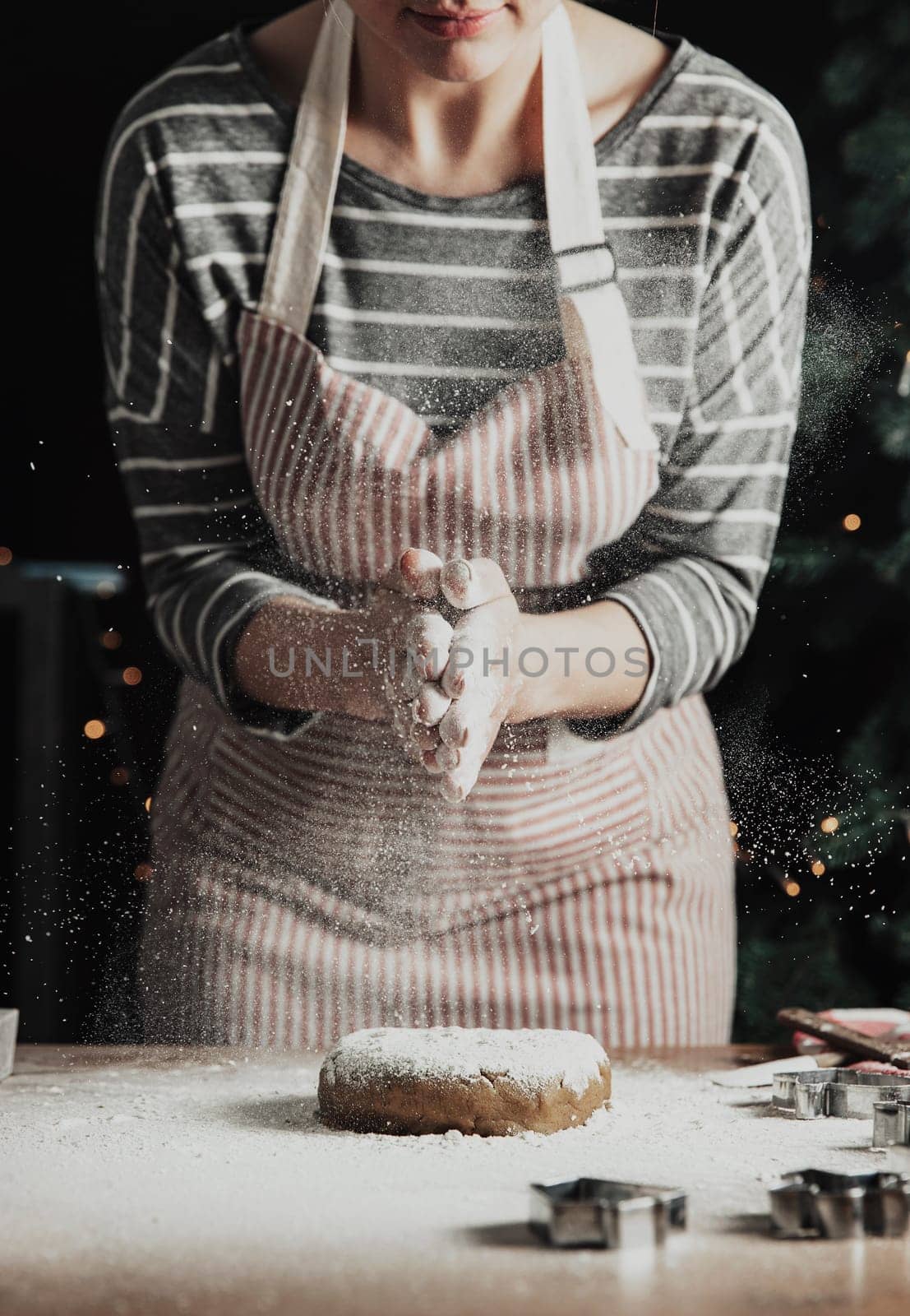 Merry Christmas, Happy New Year. Gingerbread cooking, cake, strudel baking. The woman in apron is preparing cookies. Slapping palms, splashing flour over kneaded dough. Young girl prepare, bake, cook