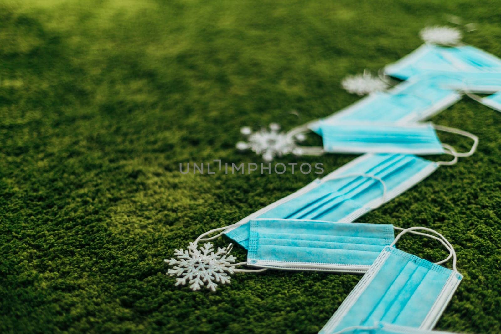 Christmas Tree Made of Blue Medical Masks on a Green Background With Copy Space