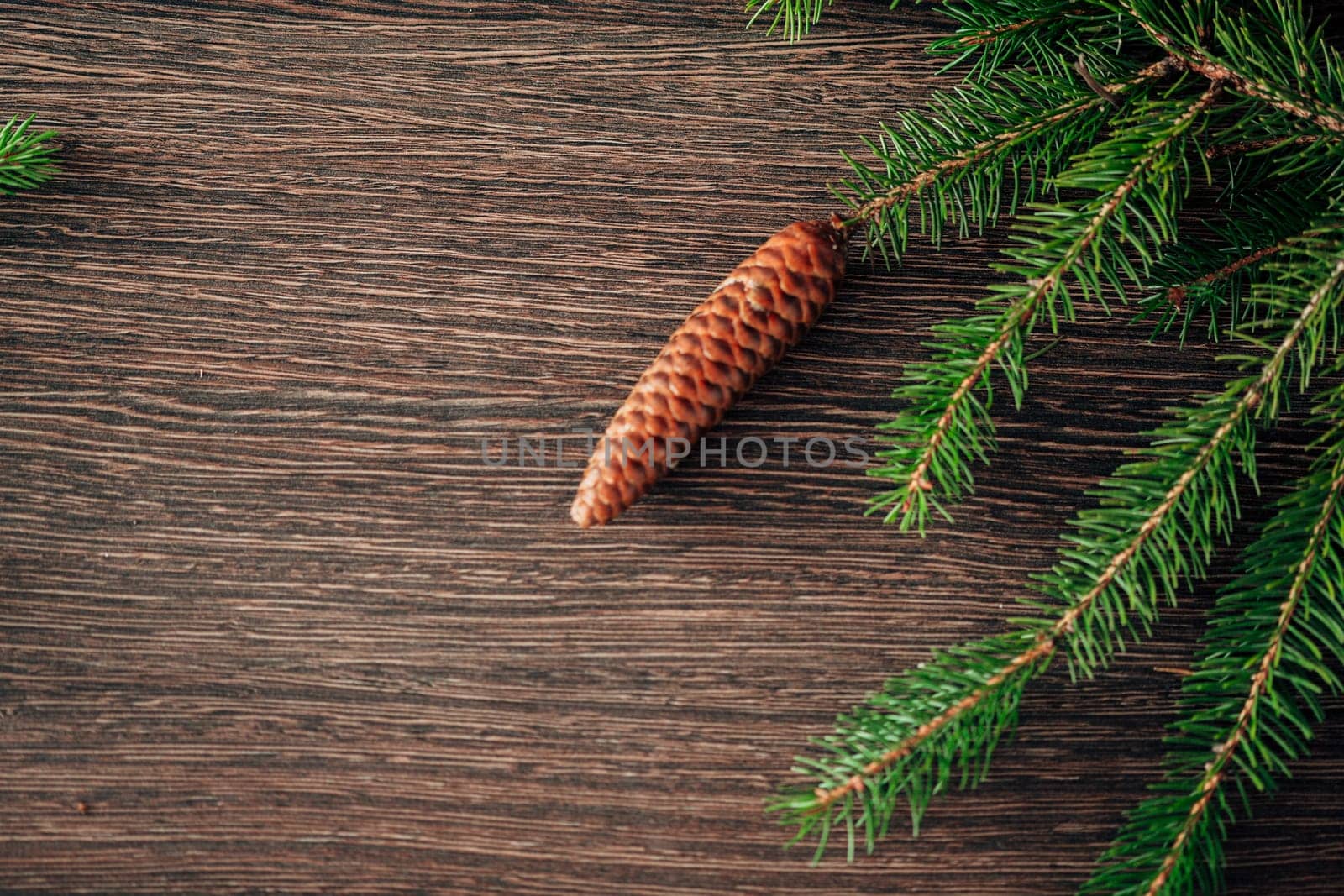 Decoration of Christmas Tree Green Branches on a Brown Background with CopySpace