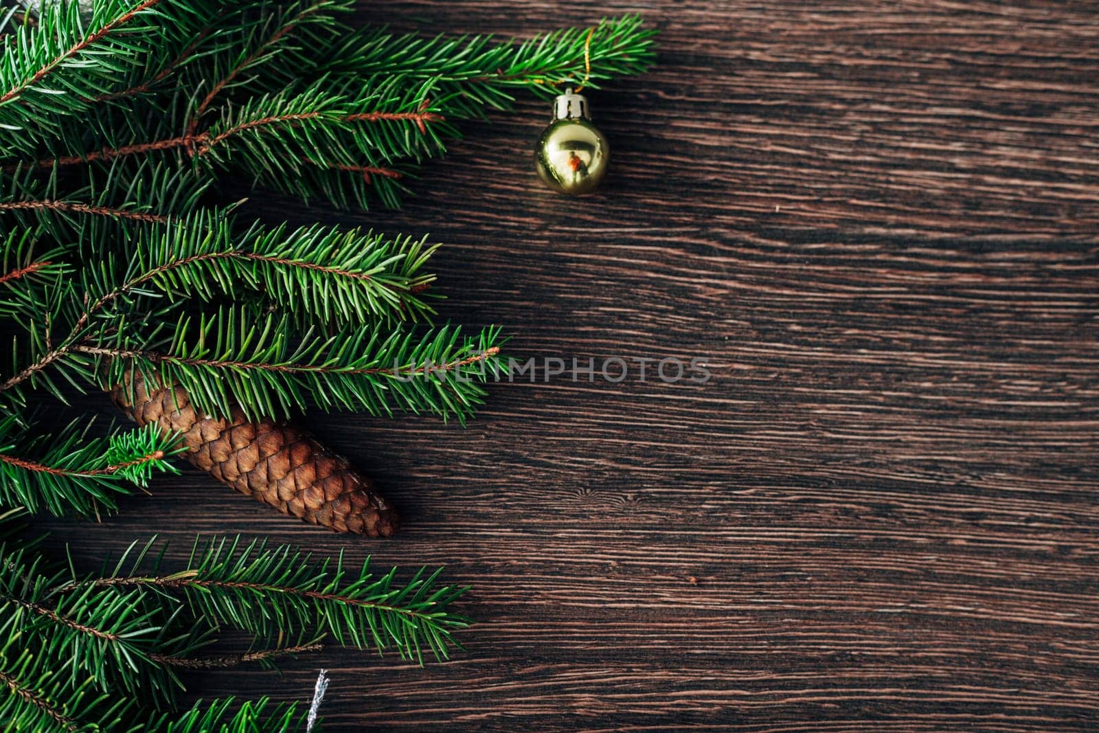Decoration of Christmas Tree Green Branches on a Brown Background with CopySpace