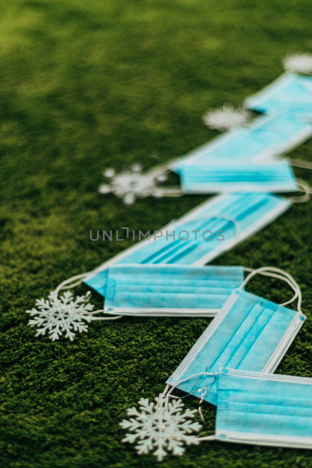 Christmas Tree Made of Blue Medical Masks on a Green Background With Copy Space