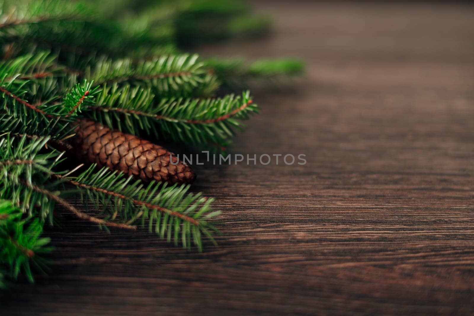 Decoration of Christmas Tree Green Branches on a Brown Background with CopySpace