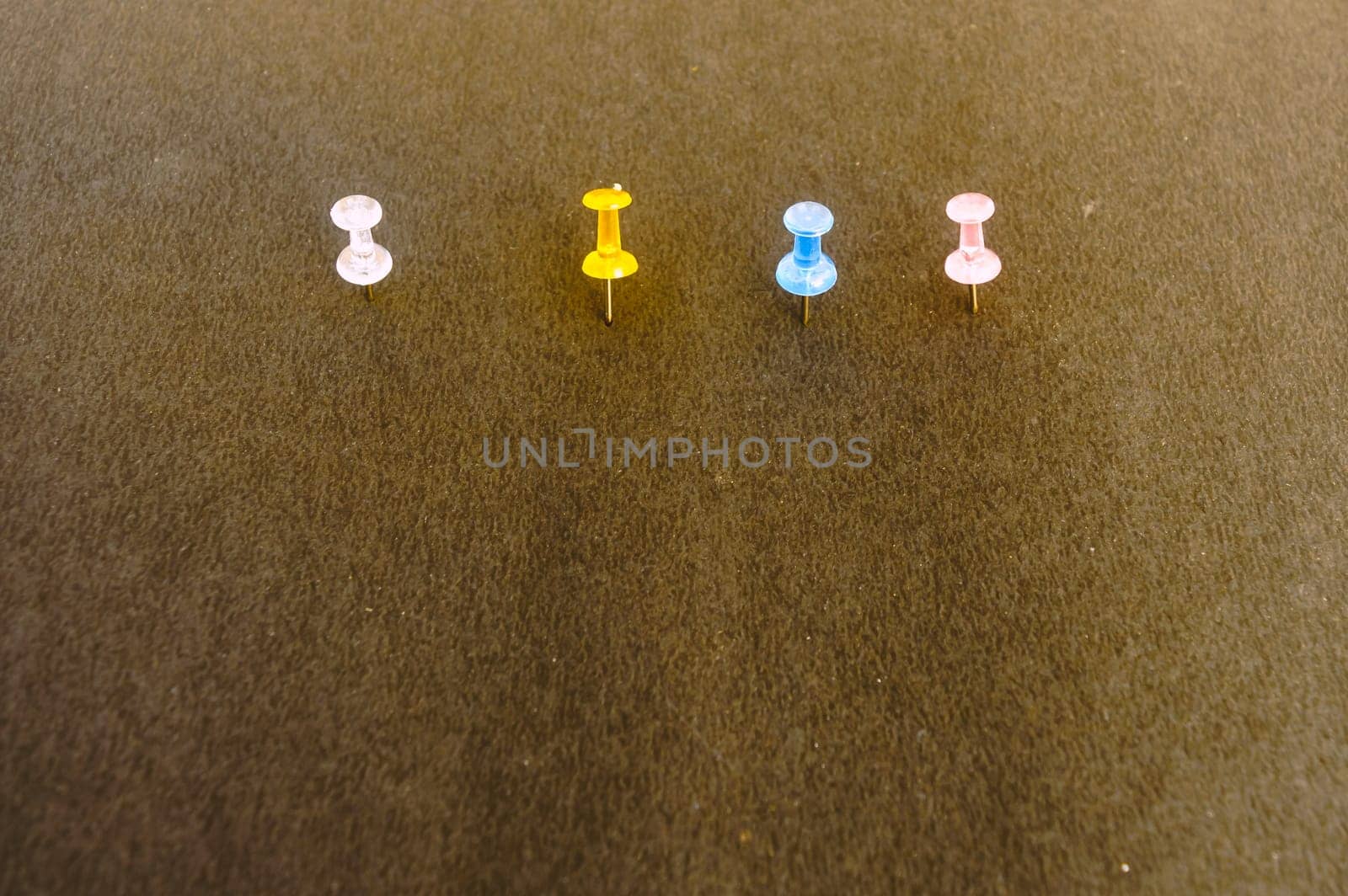 Notice Board Pin pinned attached on a brown color notice board on isolated background. High angle view.