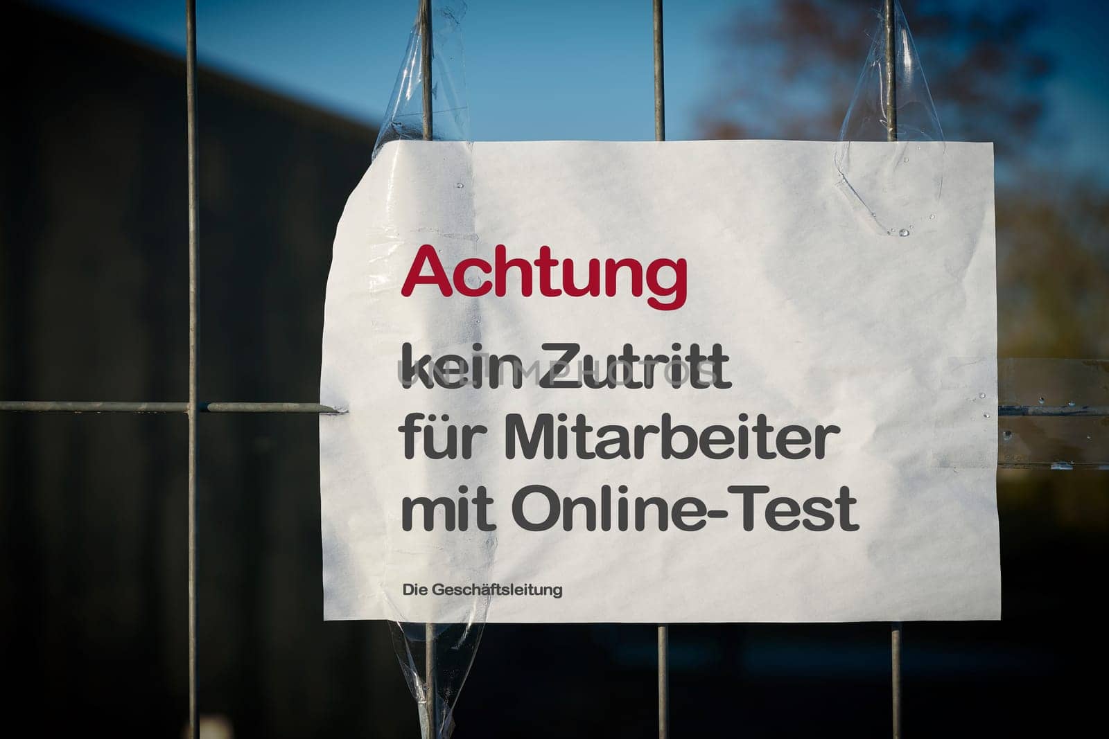 Restricting access at a fence to a company site in Germany during the Corona Pandemic. Translation: Attention, no access for employees with online test