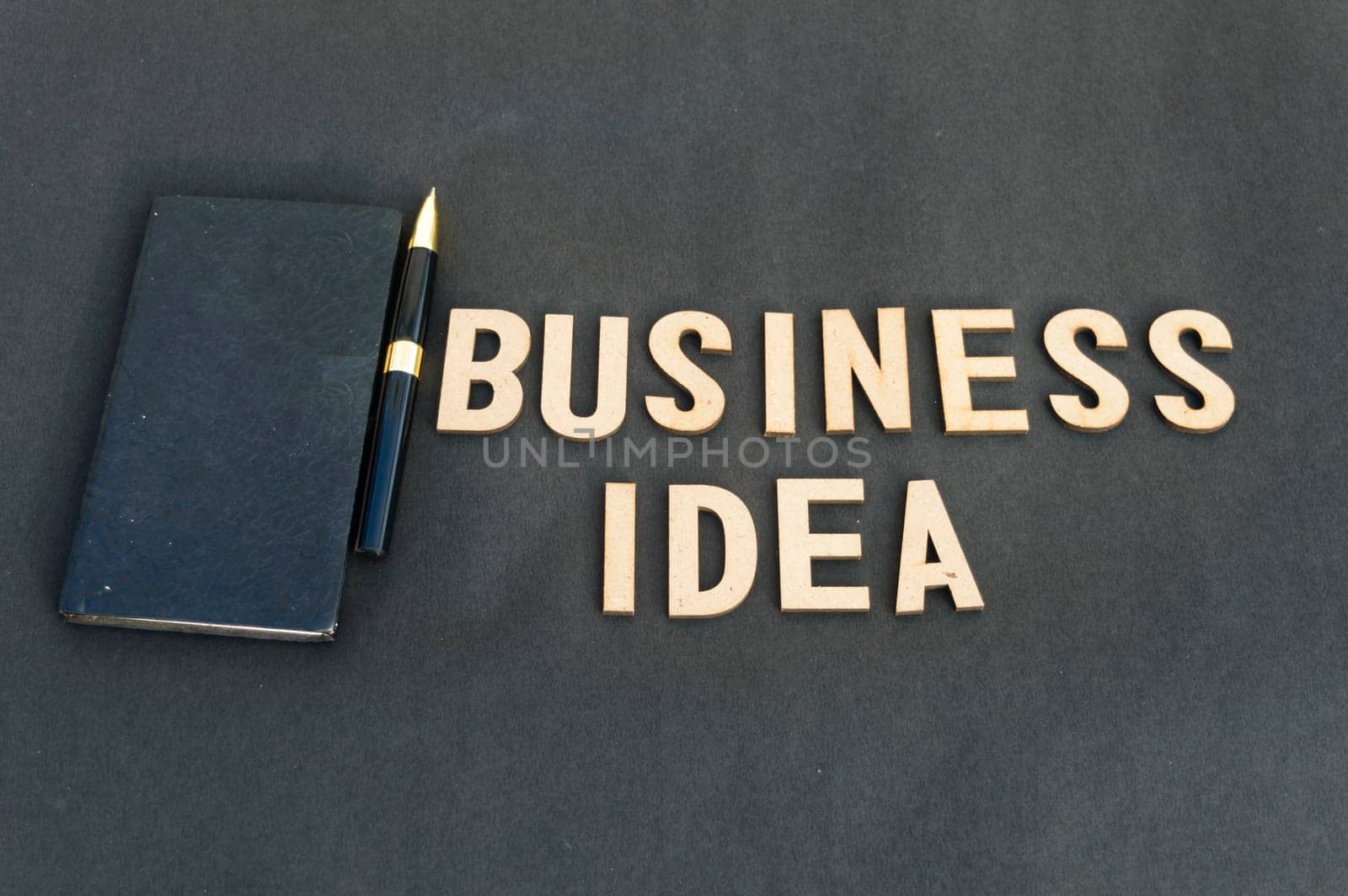 business idea background concept. Wooden cubes words Business ideas isolated on black background. Design for ideal poster, web, cover, ad, social media, promotion.