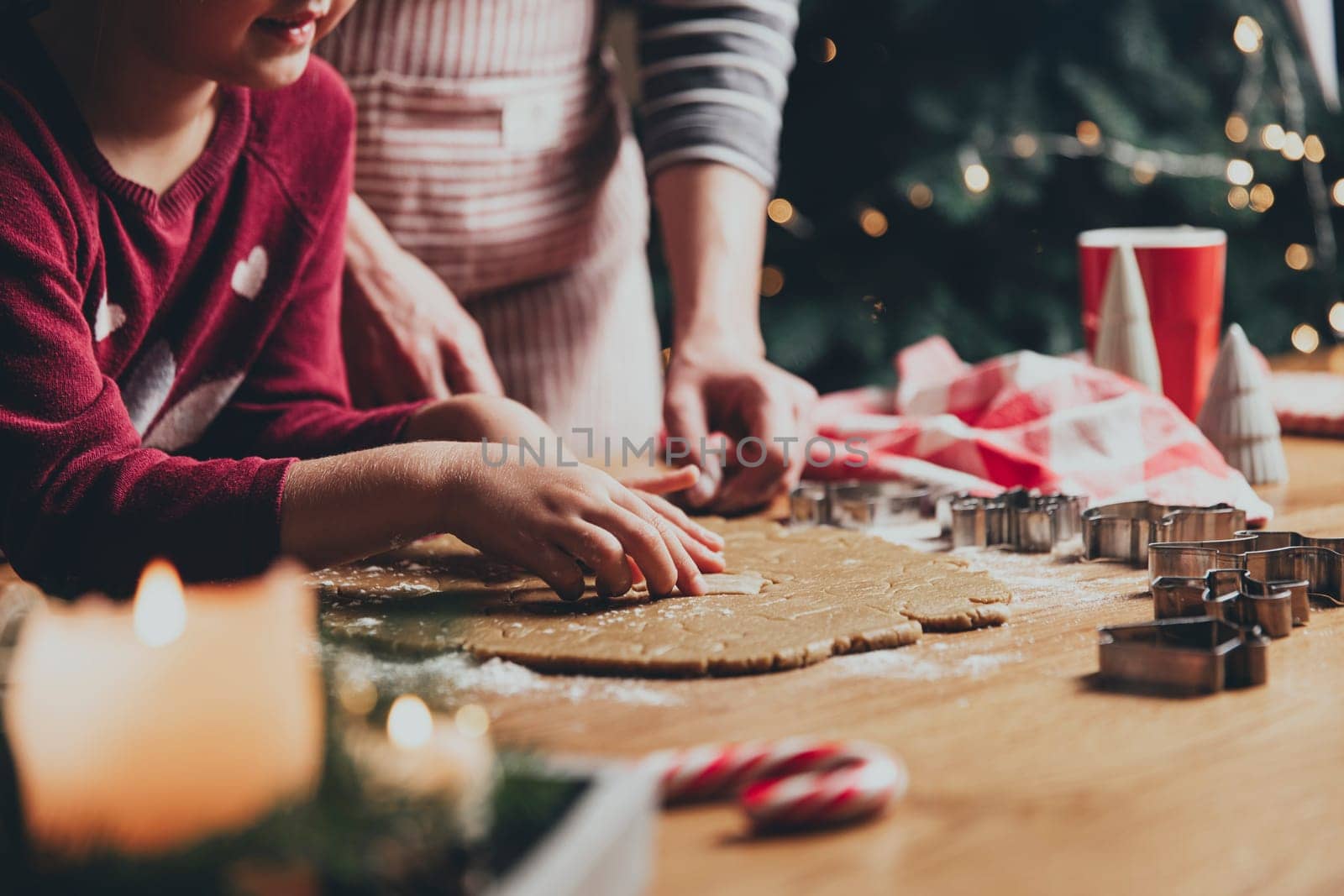 Merry Christmas, Happy New Year. Gingerbread cooking, baking. Mom and daughter make cookies, cut out different shapes of cookies using cutting metal mold on wooden table at kitchen. High quality photo