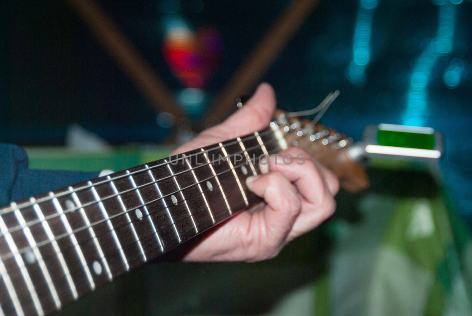 A man plays a white electric guitar