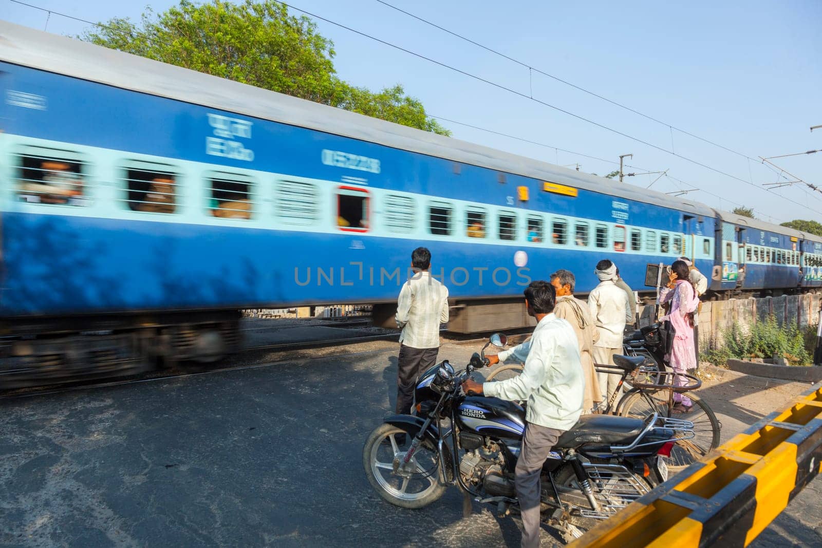 Fatehpur Sikri, India -  November 16, 2011: people wait at the railway crossing near Fatehpur Sikri, India to cross the street.
