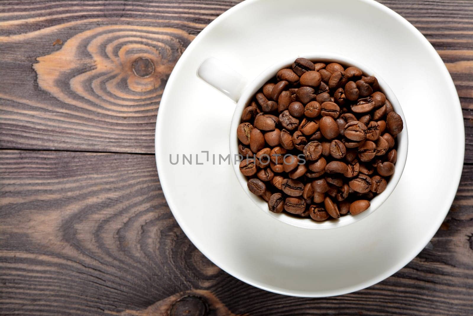 White coffee mug filled with fragrant coffee beans. High quality photo