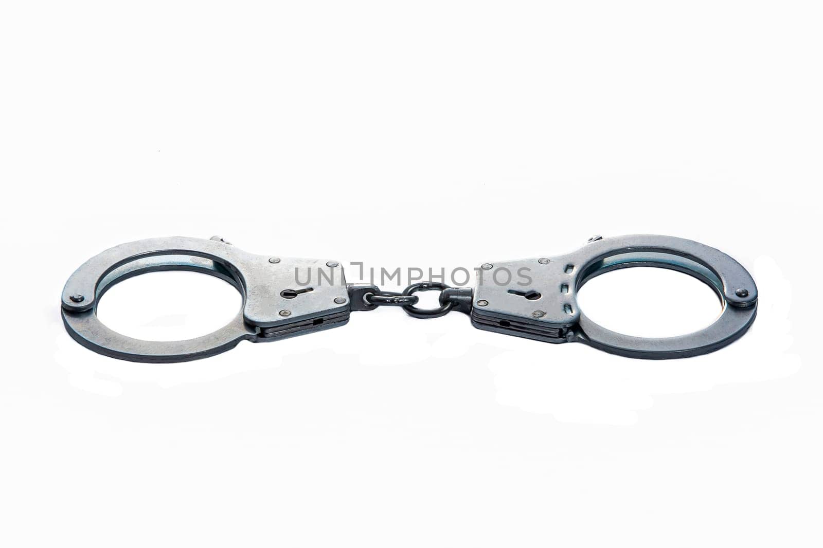 Metal handcuffs on a white isolated background. High quality photo