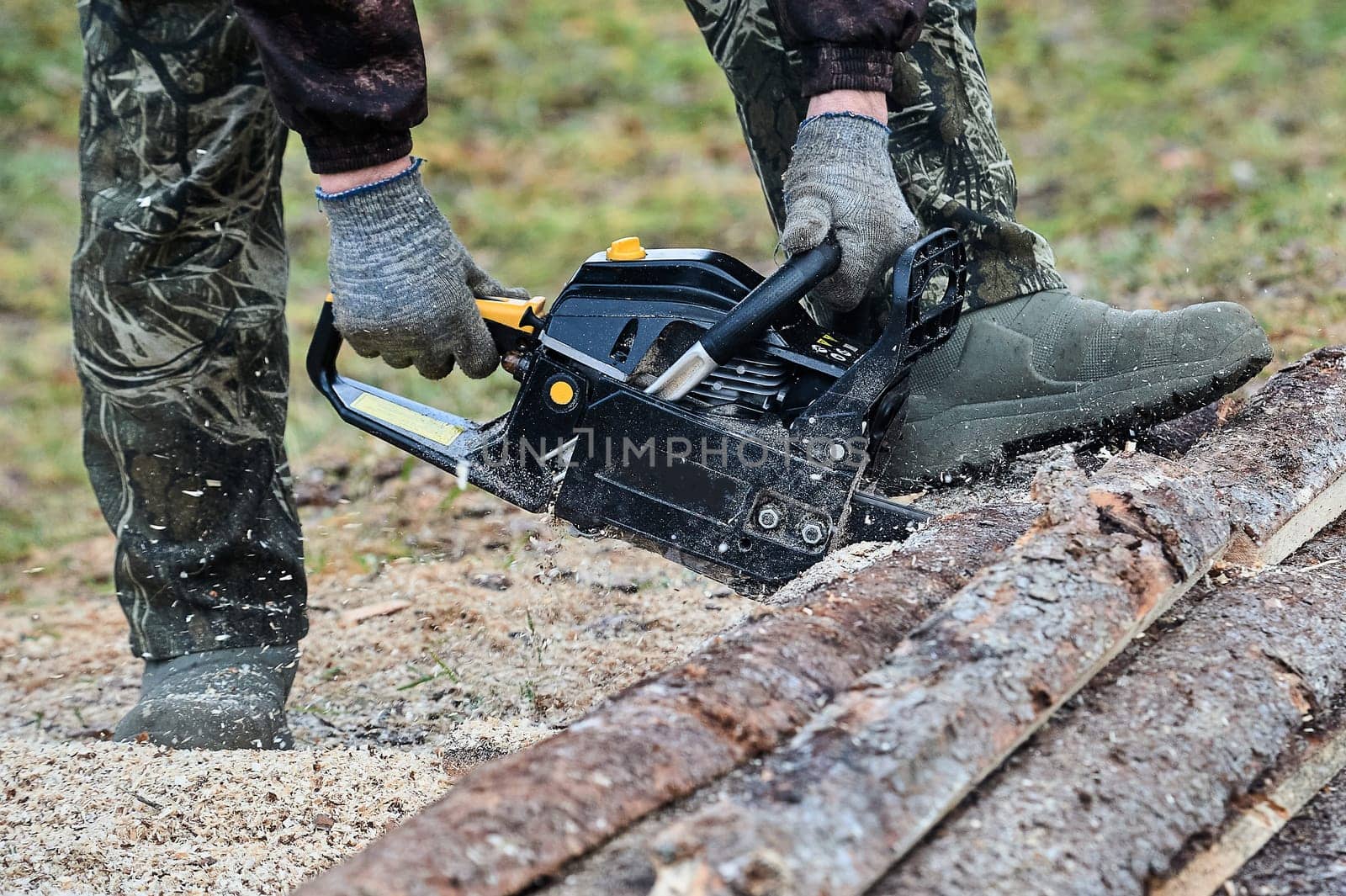 a chainsaw is used to cut wood outdoors. High quality photo