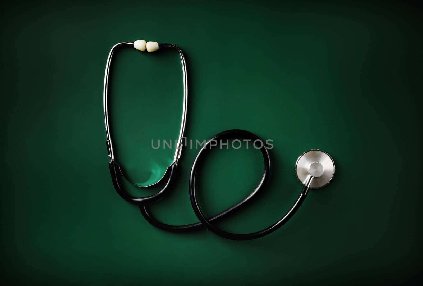 Medical stethoscope on green table background. Flat lay.