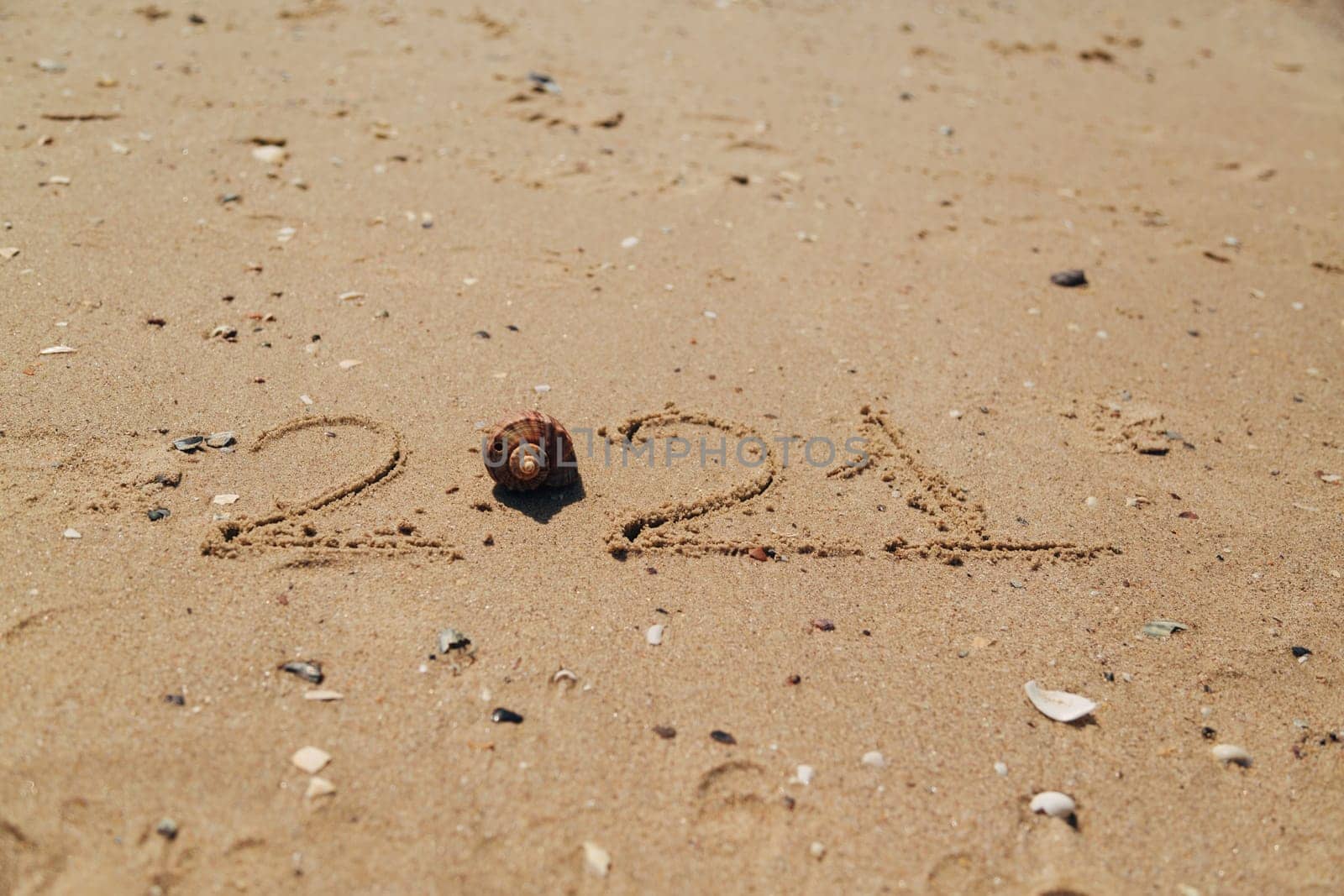 Word 2021 Written on the Sand of a Beach. New Year 2021 text on the sea beach. Vacation relax