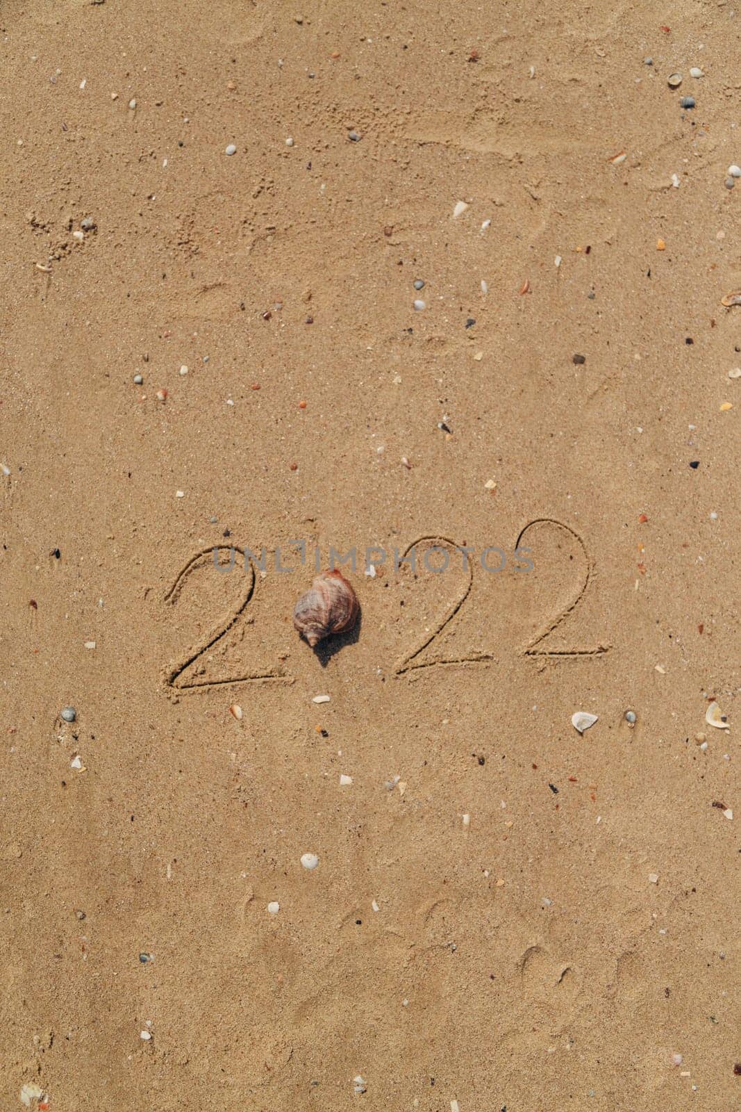 Word 2022 Written on the Sand of a Beach. With Copy Past Space