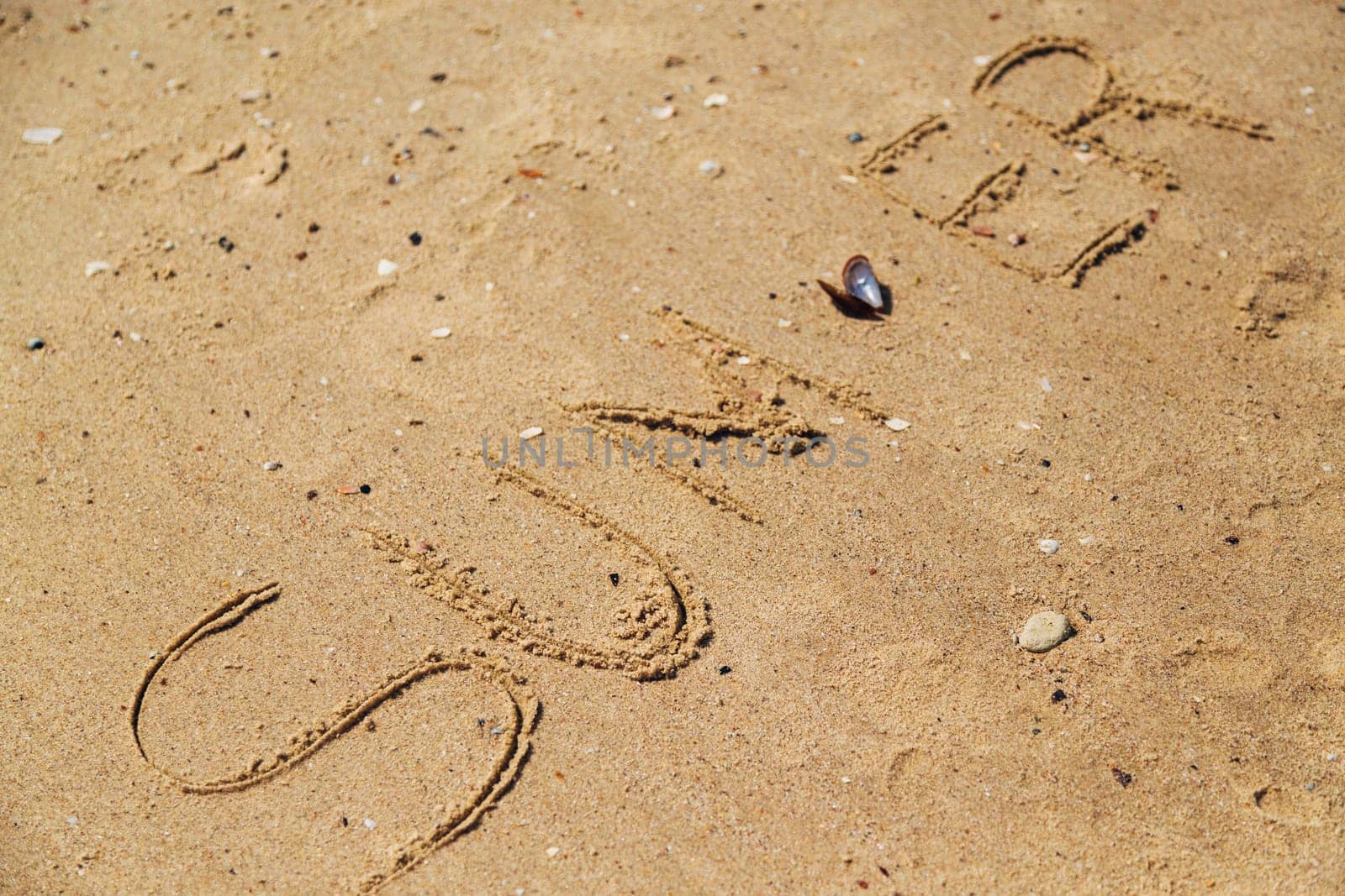 Word Summer Written on the Sand of a Beach. Text on the Golden Sea Beach.