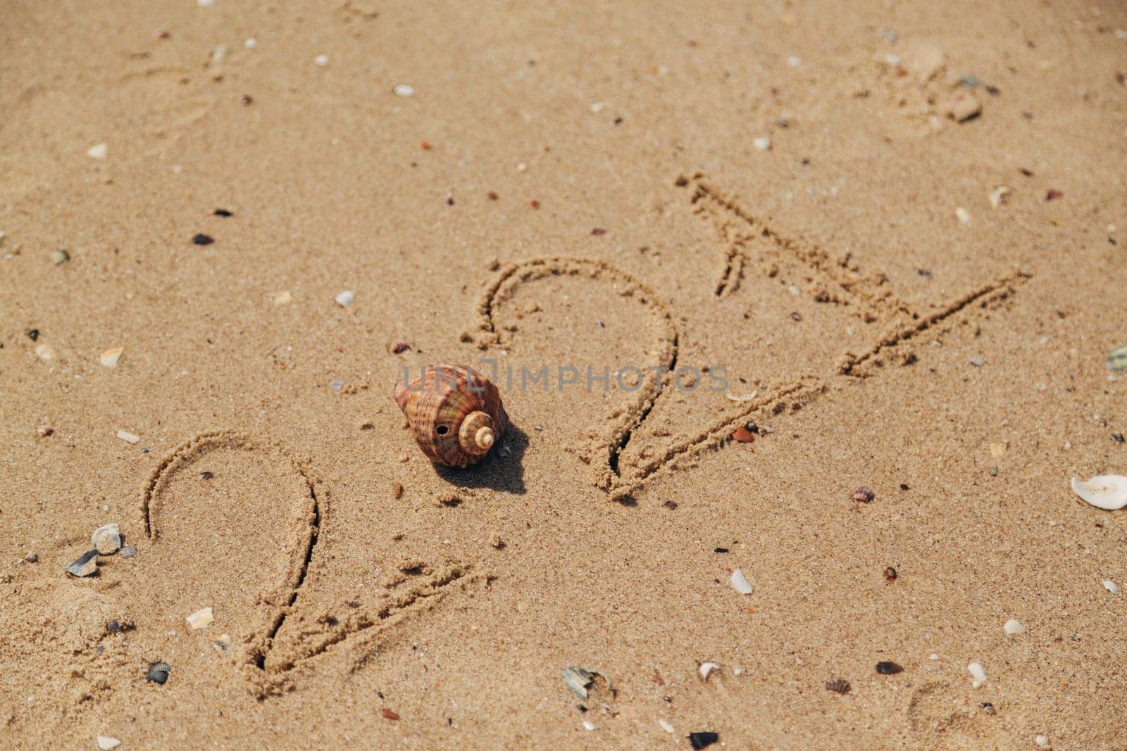 Word 2021 Written on the Sand of a Beach. New Year 2021 text on the sea beach. Vacation relax