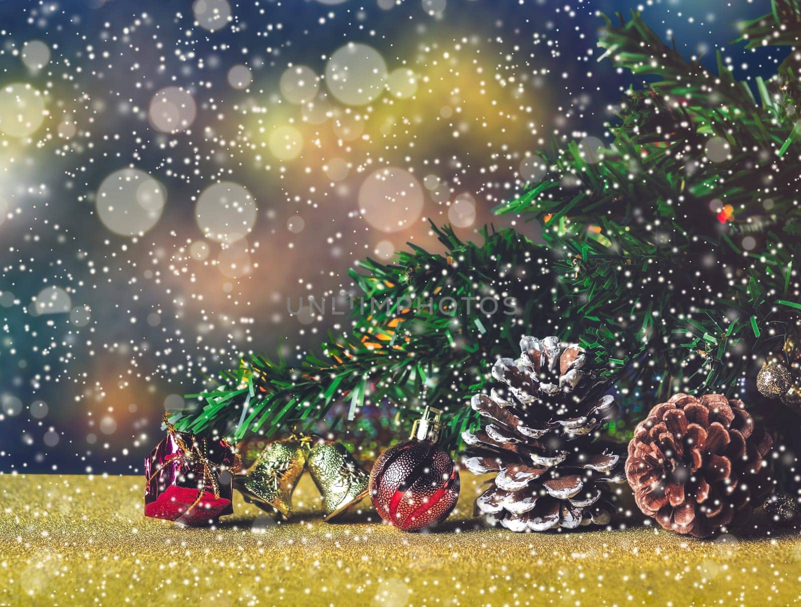 Christmas decoration with red box, bell, ball and conifers tree cones on bokeh background