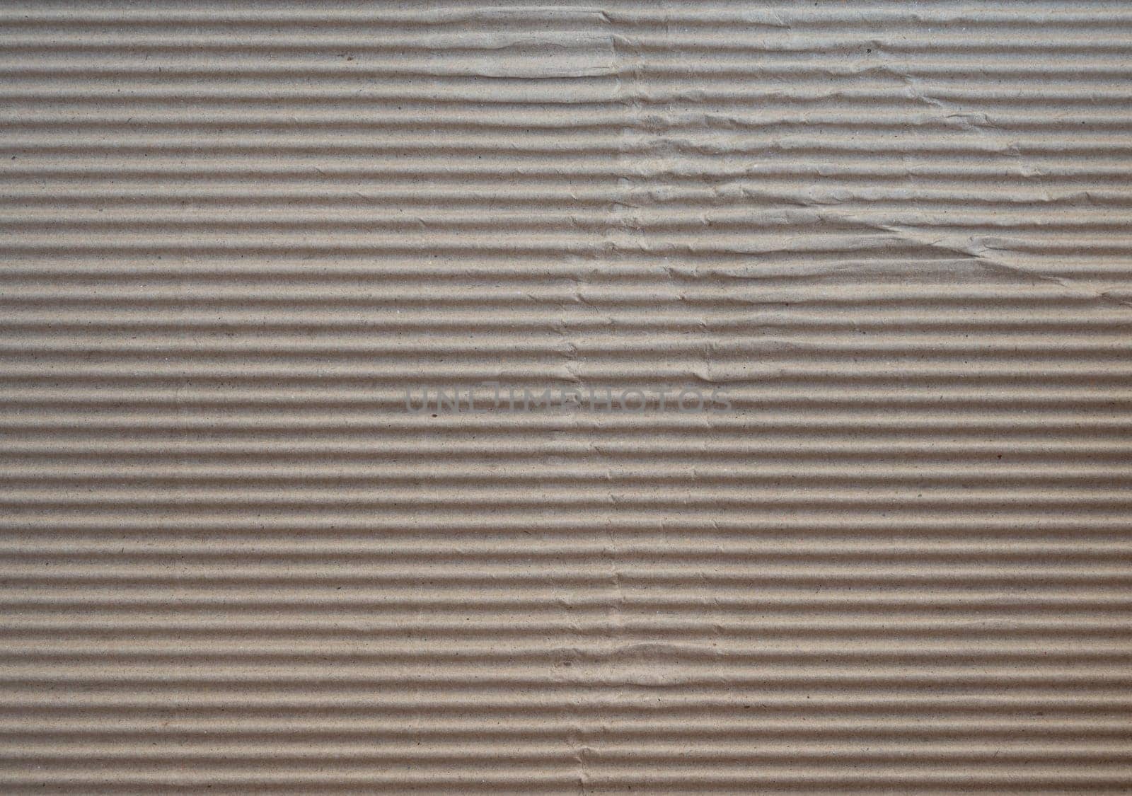 Crumpled brown paper craft texture background of fluted corrugated fiberboard sheet