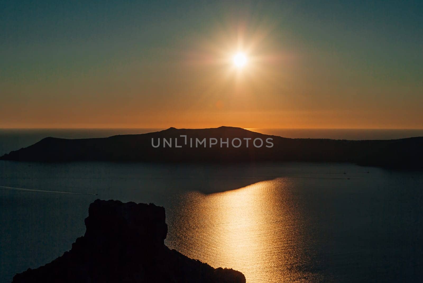 Sunset view over the caldera against the backdrop of the rock of Skaros.