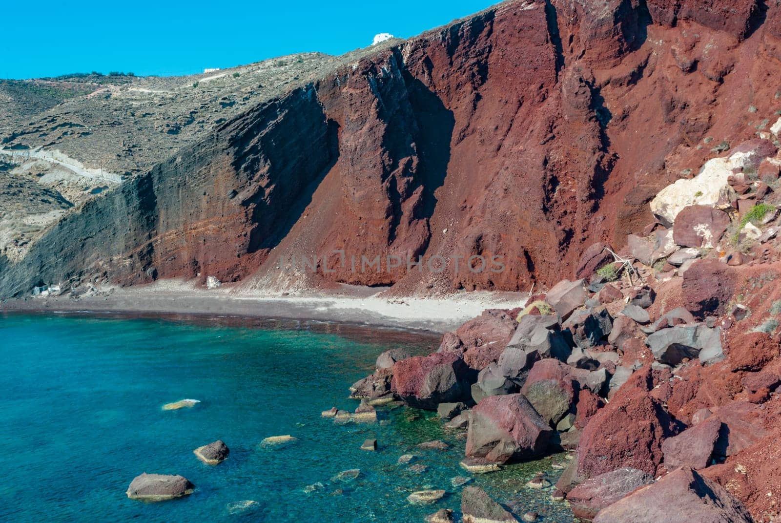 Red Cliffs and Turquoise Water of Santorini's Red Beach.
