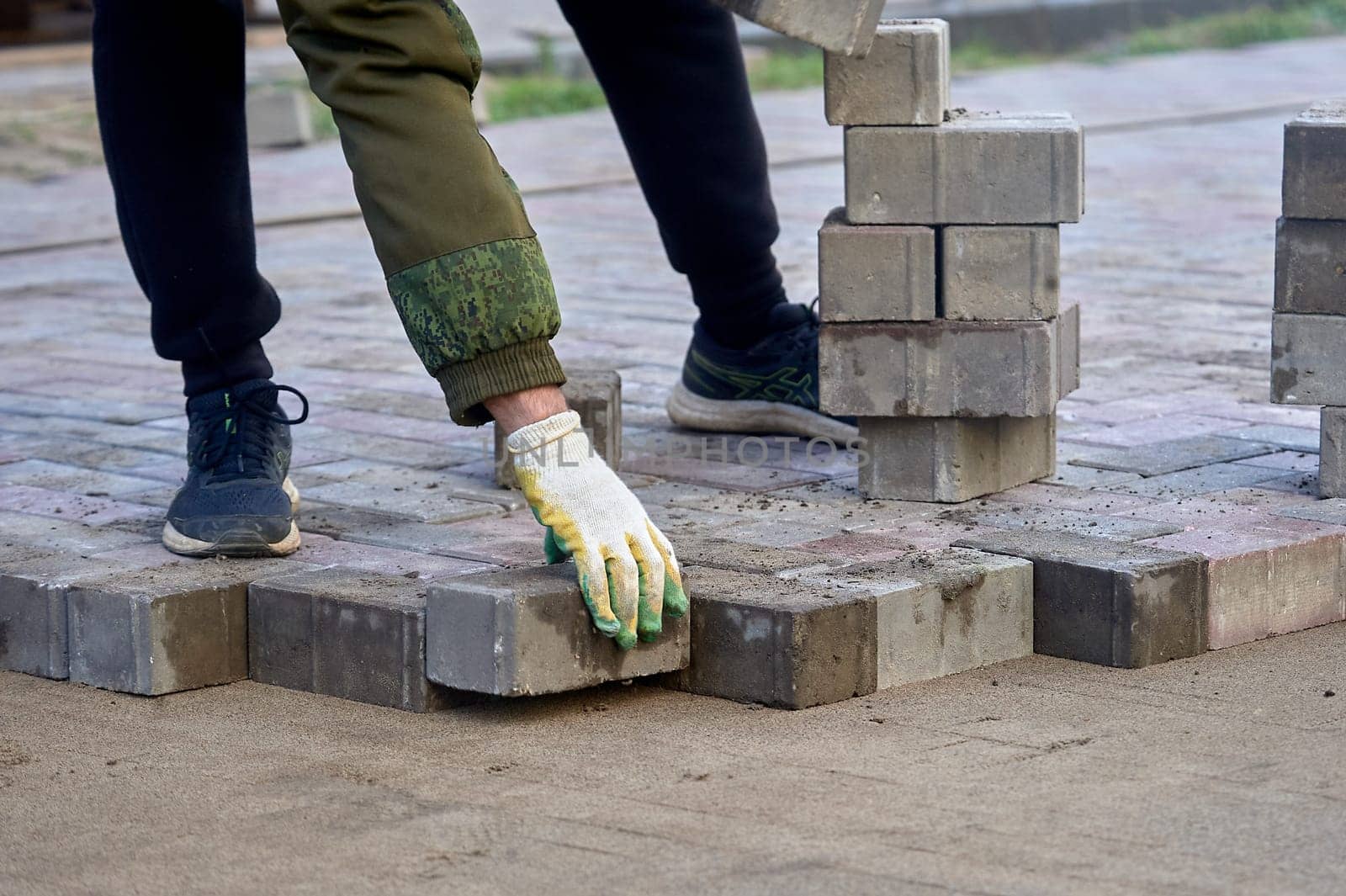 laying paving slabs on the sand with your hands. High quality photo