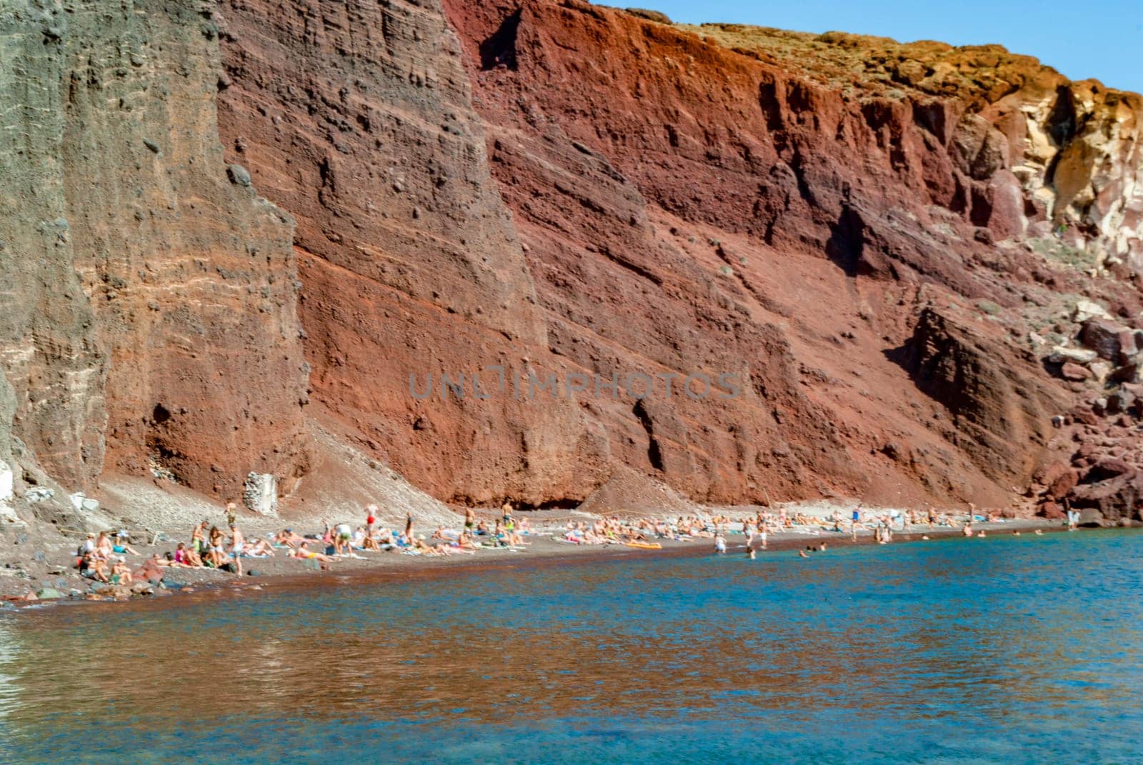Tourists on the shores of the Red Beach in Santorini.