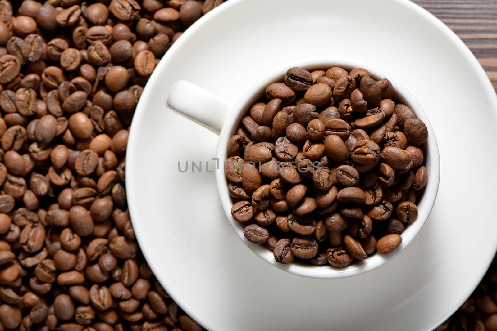 White coffee mug filled with coffee beans. High quality photo