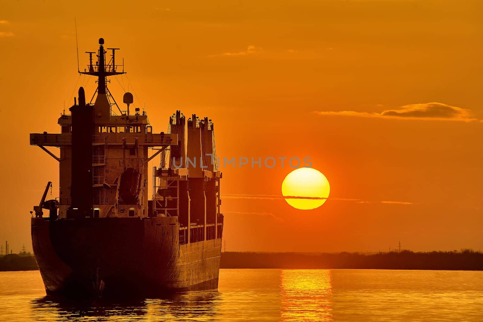 The ship is standing in the roadstead against the background of sunset. High quality photo