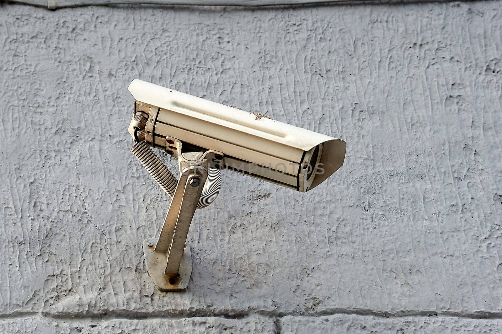 A security camera is hanging on a concrete post. High quality photo