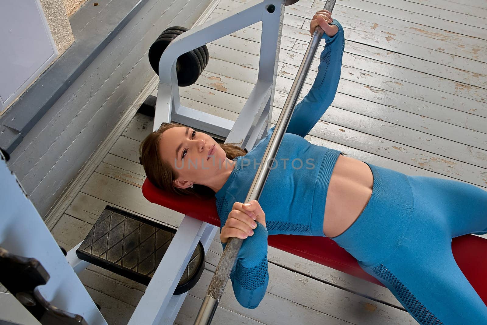 a young woman does a bench press lying on her back. High quality photo