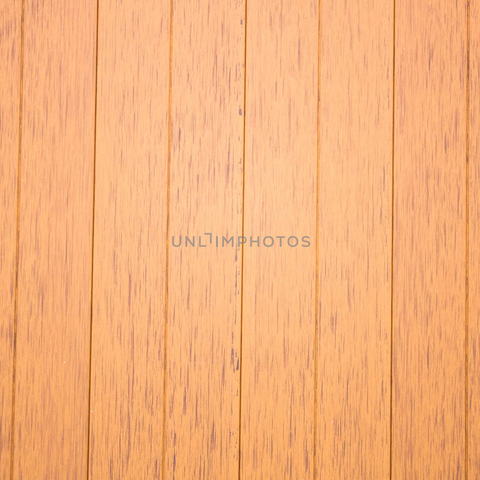 In front of a panel of Faux wood.