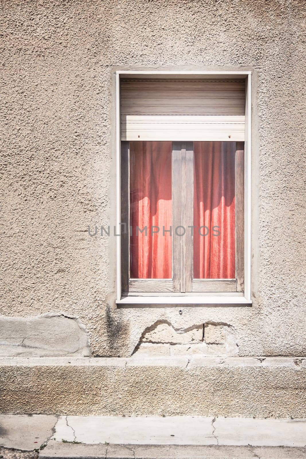 Red curtain behind the window on gray wall