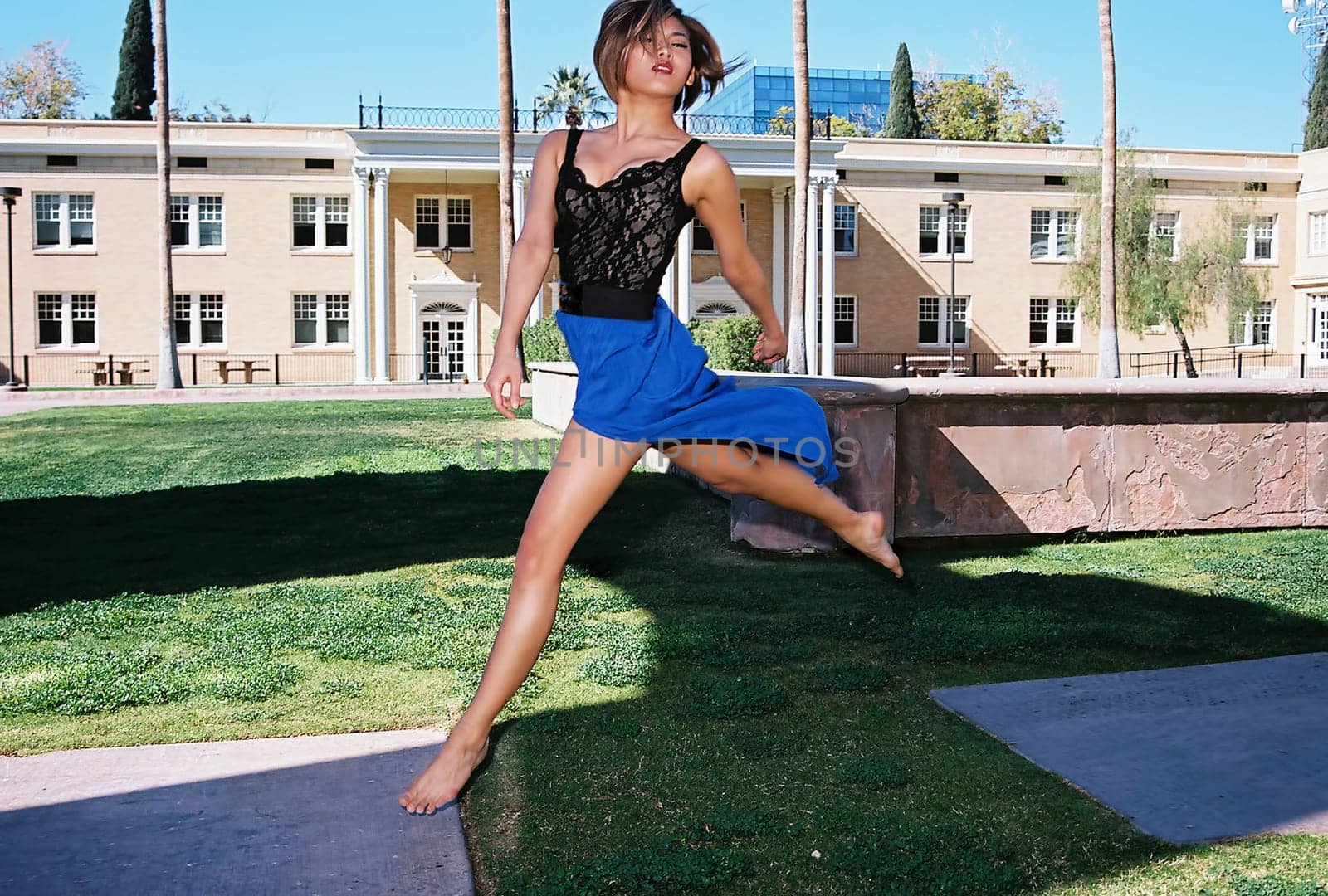 A lovely Asian female model jumping outdoors