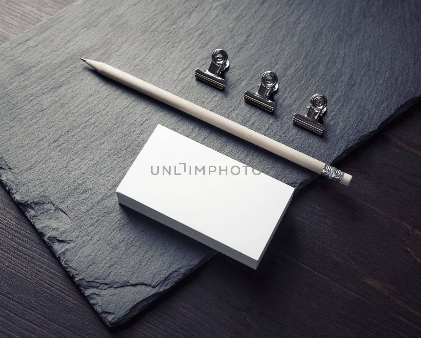 Photo of blank business cards, pencil and clips. Mockup for ID.