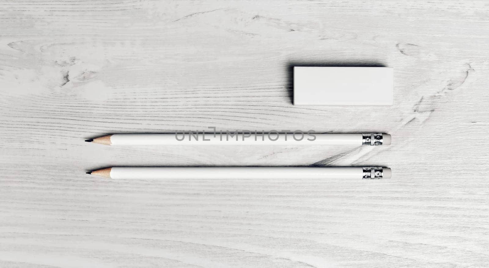 Simple blank pencils and eraser on light wooden background. Top view. Flat lay.