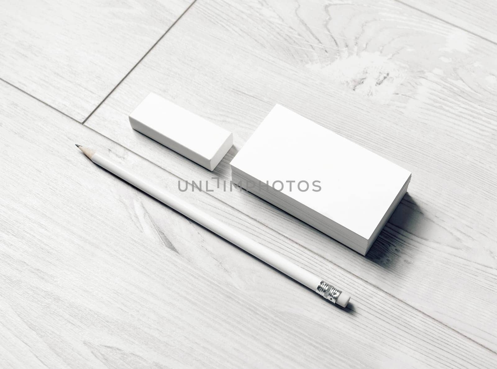 Blank stationery set. Blank business cards, pencil and eraser on light wooden background.