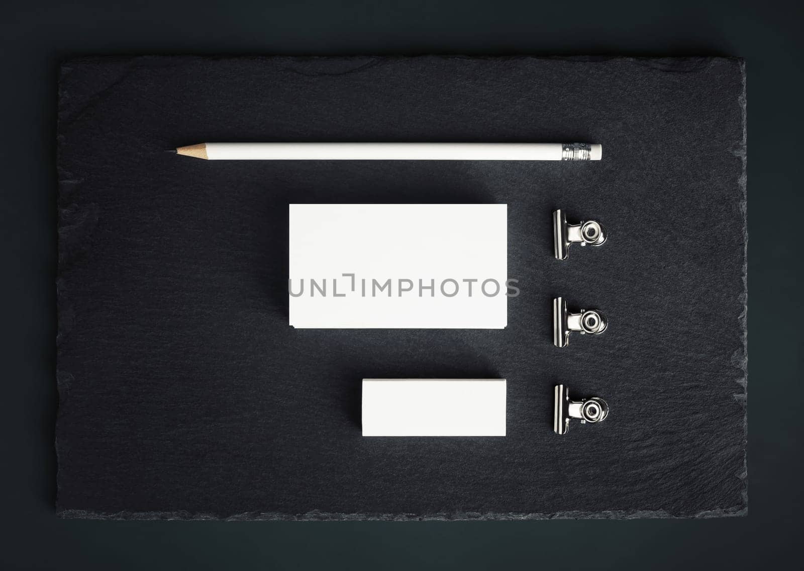 Blank stationery template. Blank business card, pencil, eraser and clips. Top view. Flat lay.