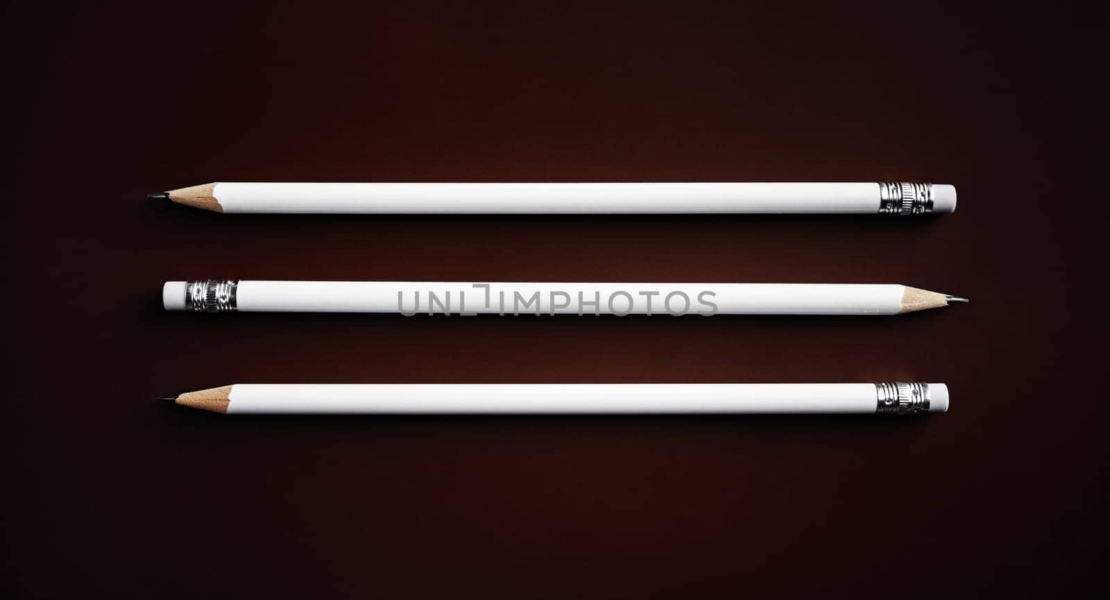 Three simple blank pencils on dark background. Top view. Flat lay.