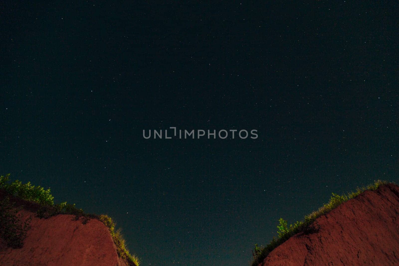 Night Dark Sky with Lots of Bright White Stars and Constellation over the Two Mountain Peaks.