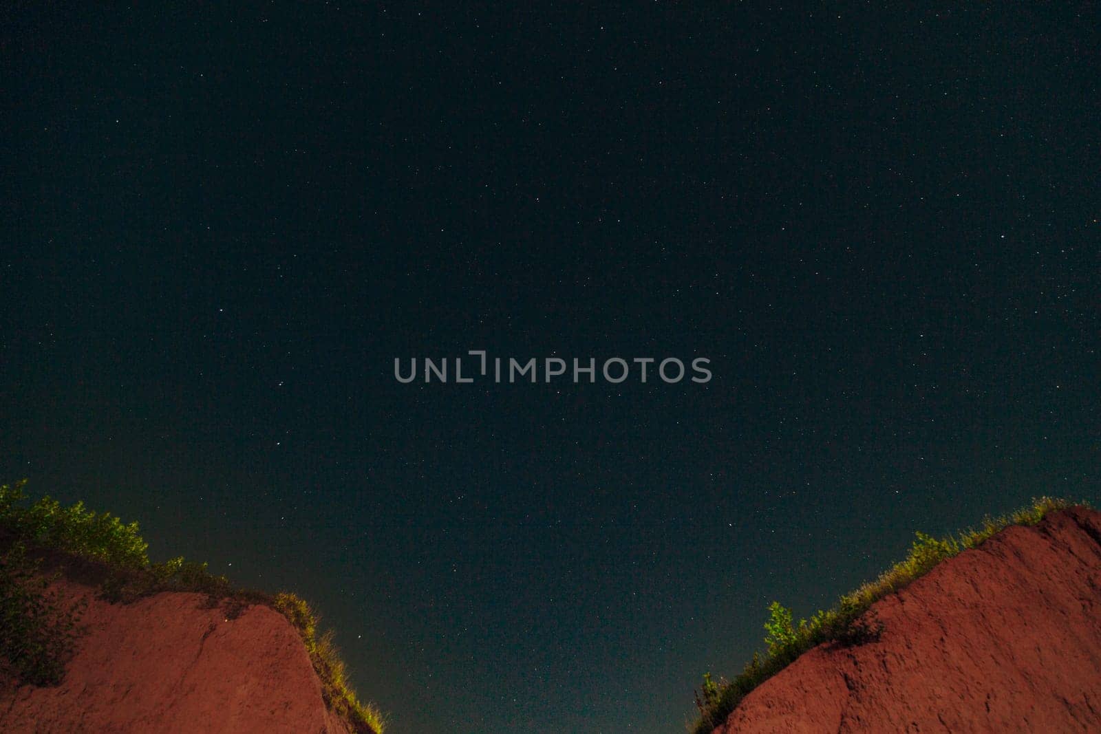 Night Dark Sky with Lots of Bright White Stars and Constellation over the Two Mountain Peaks.
