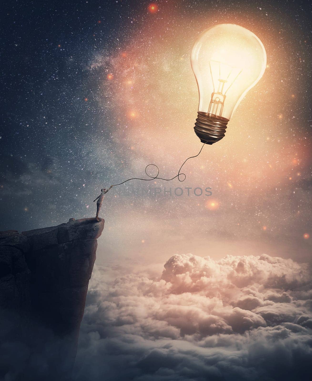 Creative idea concept with a person on the edge of a cliff holding the string of a lightbulb kite or a bulb balloon. Surreal adventure, conceptual scene, genius thinking