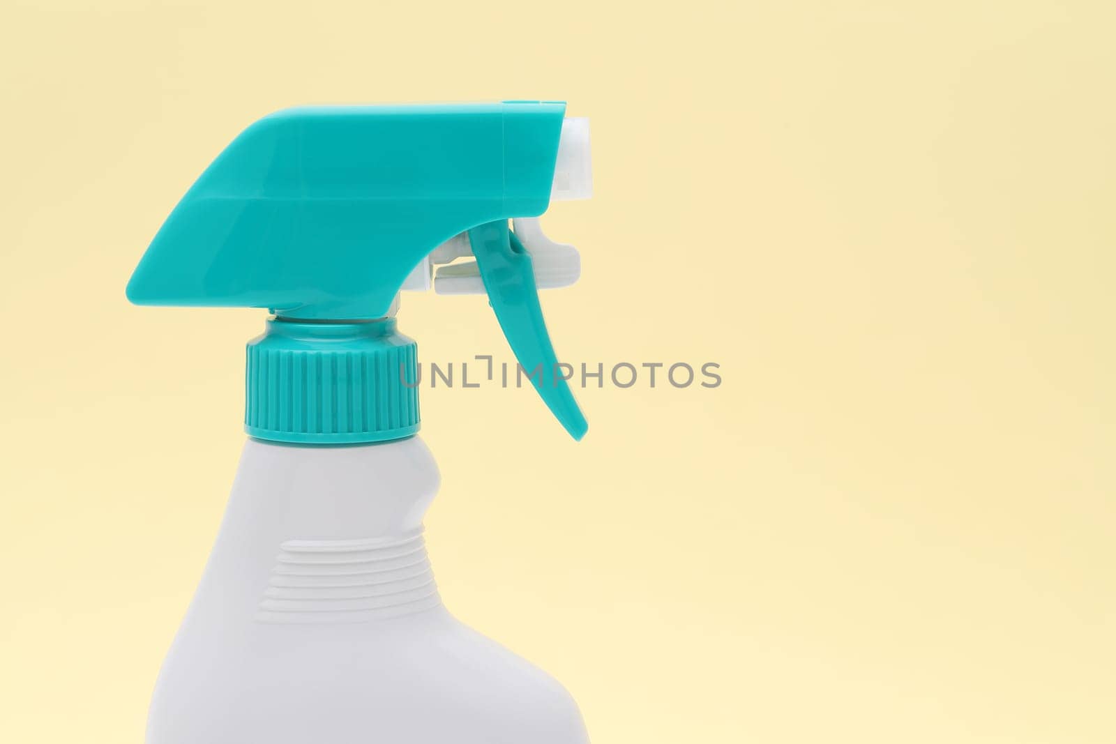 close up of white plastic bottle with spray and foam nozzle on pink background