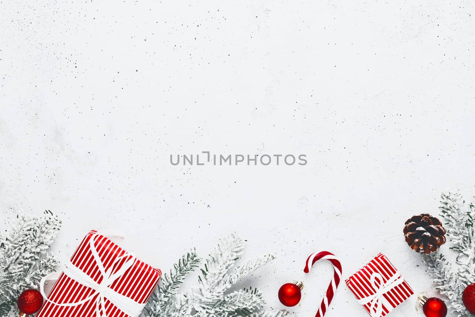 Christmas, New Year gray concrete flat lay with red white present gift boxes top view. Gift ribbon and packaging paper. Christmas tree fir, cones, toys, candy stick lolly, Copy space text area